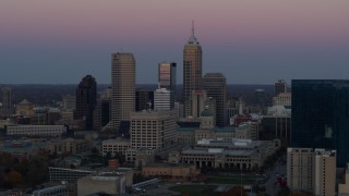 DX0001_002947 - 5.7K aerial stock footage of a reverse view of the city's skyline at sunset in Downtown Indianapolis, Indiana