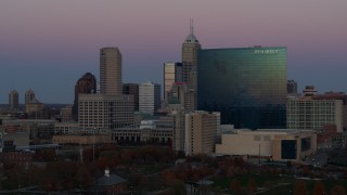 DX0001_002951 - 5.7K aerial stock footage slowly flyby a hotel at sunset with skyline in background, Downtown Indianapolis, Indiana