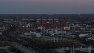 DX0001_002954 - 5.7K aerial stock footage reverse view and flyby of a football stadium at sunset, Downtown Indianapolis, Indiana