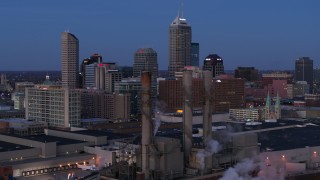DX0001_002960 - 5.7K stock footage aerial video flyby smoke stacks for view of city skyline at twilight in Downtown Indianapolis, Indiana