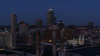 DX0001_002970 - 5.7K aerial stock footage flyby giant skyscrapers of the city skyline at twilight, reveal smoke stacks, Downtown Indianapolis, Indiana