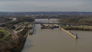 DX0001_003014 - 5.7K aerial stock footage descend near locks and a dam on the Ohio River in Louisville, Kentucky