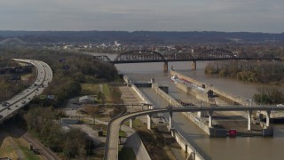 DX0001_003016 - 5.7K stock footage aerial video flying by railroad bridge near locks and a dam on the Ohio River in Louisville, Kentucky