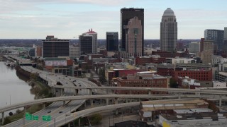 DX0001_003023 - 5.7K aerial stock footage descend near freeway with view of skyscrapers in Downtown Louisville, Kentucky