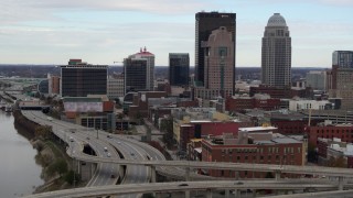 DX0001_003024 - 5.7K stock footage aerial video ascend over freeway with view of skyscrapers in Downtown Louisville, Kentucky