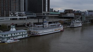 DX0001_003060 - 5.7K aerial stock footage of historic riverboat docked by Downtown Louisville, Kentucky
