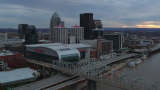 DX0001_003068 - 5.7K aerial stock footage flyby bridge and ascend near arena and skyline at sunset, Downtown Louisville, Kentucky