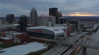 DX0001_003069 - 5.7K aerial stock footage fly away from arena and skyline, reveal bridge and Ohio River at sunset, Downtown Louisville, Kentucky