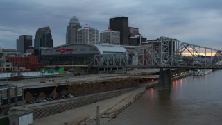 DX0001_003073 - 5.7K aerial stock footage flyby freeway near the arena and city skyline, and bridge spanning river at sunset, Downtown Louisville, Kentucky