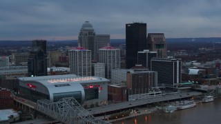 DX0001_003084 - 5.7K stock footage aerial video fly away from arena and city skyline at sunset, reveal river, Downtown Louisville, Kentucky