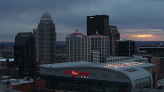 DX0001_003092 - 5.7K stock footage aerial video descend by arena at sunset and focus on the skyline, Downtown Louisville, Kentucky