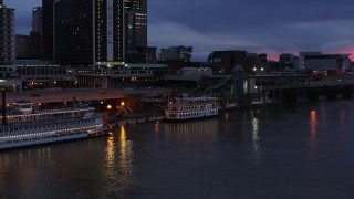 DX0001_003093 - 5.7K stock footage aerial video orbit small riverboat at twilight in Downtown Louisville, Kentucky