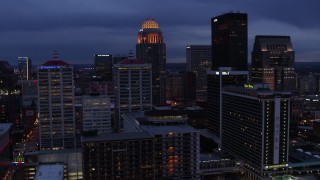 DX0001_003100 - 5.7K aerial stock footage of flying by hotel, with the skyline lit up at twilight, Downtown Louisville, Kentucky