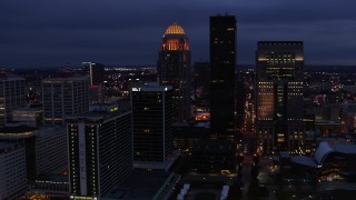 DX0001_003107 - 5.7K aerial stock footage reverse view of a tall skyscraper and skyline lit up at twilight, Downtown Louisville, Kentucky