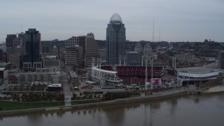 DX0001_003128 - 5.7K aerial stock footage descend toward river with view of the baseball stadium and skyscraper, Downtown Cincinnati, Ohio