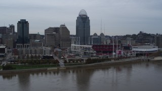 DX0001_003129 - 5.7K aerial stock footage slow pass over river with view of the baseball stadium and skyscraper, Downtown Cincinnati, Ohio
