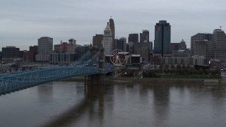 DX0001_003133 - 5.7K aerial stock footage of the city skyline and Roebling Bridge seen from the Ohio River, Downtown Cincinnati, Ohio