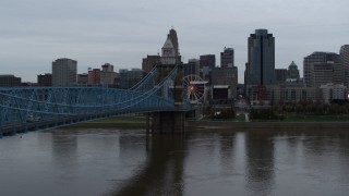 DX0001_003137 - 5.7K aerial stock footage ascend by bridge from river toward the city skyline, Downtown Cincinnati, Ohio