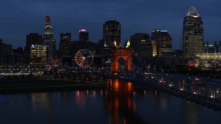 DX0001_003181 - 5.7K stock footage aerial video ascend from river by bridge to approach city skyline at twilight, Downtown Cincinnati, Ohio