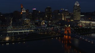 DX0001_003187 - 5.7K aerial stock footage flying by the city skyline at twilight, seen from river near bridge, Downtown Cincinnati, Ohio
