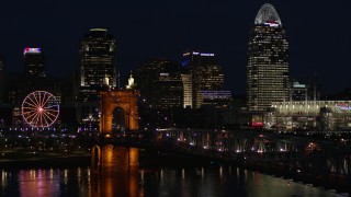 DX0001_003191 - 5.7K stock footage aerial video fly over Roebling Bridge at night to approach city skyline, Downtown Cincinnati, Ohio