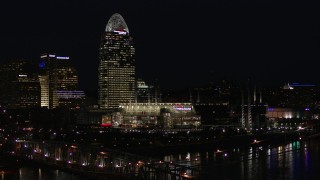 DX0001_003196 - 5.7K aerial stock footage descend by tall skyscraper and the baseball stadium at night, reveal bridge, Downtown Cincinnati, Ohio