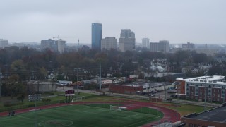 DX0001_003203 - 5.7K stock footage aerial video ascend from football field for view of the city skyline, Downtown Lexington, Kentucky