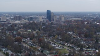 DX0001_003232 - 5.7K aerial stock footage of city skyline while flying past tree-lined neighborhoods, Downtown Lexington, Kentucky
