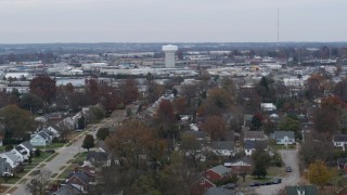 DX0001_003238 - 5.7K aerial stock footage descend toward homes with view of a water tower surrounded by warehouses in Lexington, Kentucky