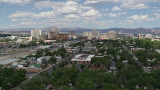 DX0001_004_049 - 5.7K aerial stock footage of descending behind trees with a view of hotels and casinos of the city's skyline in Reno, Nevada