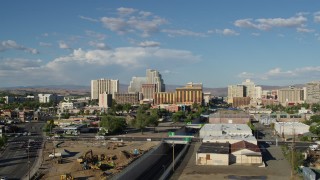 DX0001_005_004 - 5.7K aerial stock footage of a reverse view of train tracks leading to the city skyline in Reno, Nevada