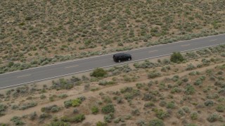 DX0001_007_019 - 5.7K stock footage aerial video of tracking a black SUV on a desert road in Carson City, Nevada