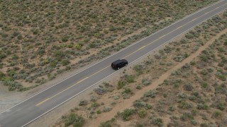DX0001_007_020 - 5.7K stock footage aerial video approach a black SUV parked on a desert road in Carson City, Nevada