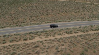 DX0001_007_022 - 5.7K stock footage aerial video track a black SUV as it drives on a desert road in Carson City, Nevada