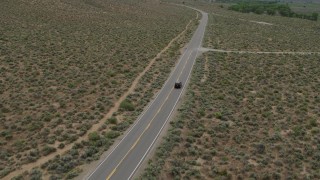 DX0001_007_025 - 5.7K stock footage aerial video of a black SUV traveling on a desert road in Carson City, Nevada
