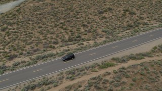 DX0001_007_029 - 5.7K stock footage aerial video of a black SUV driving on a desert road in Carson City, Nevada