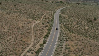 DX0001_007_030 - 5.7K stock footage aerial video of a black SUV driving on a lonely desert road in Carson City, Nevada