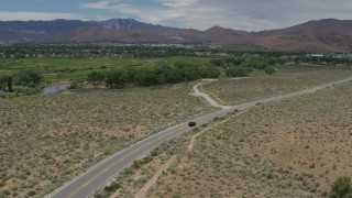 DX0001_007_033 - 5.7K stock footage aerial video of a black SUV driving on a desert road in Carson City, Nevada