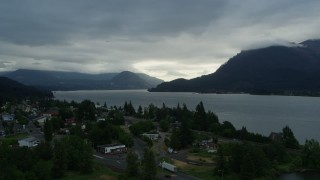 DX0001_008_002 - 5.7K aerial stock footage approach the Columbia River and cloud-shrouded mountains at sunrise, Stevenson, Washington