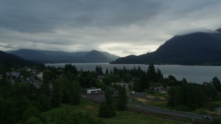 DX0001_008_003 - 5.7K aerial stock footage fly away from the Columbia River and cloud-shrouded mountains at sunrise, Stevenson, Washington