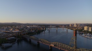 DX0001_010_021 - 4K aerial stock footage flying over Hawthorne Bridge, approaching Morrison Bridge, Downtown Portland, Oregon, sunrise