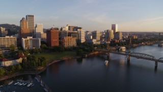 DX0001_010_022 - 4K aerial stock footage flying by Riverplace Marina, approaching Hawthorne Bridge and Downtown Portland, sunrise, Oregon