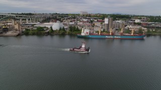 DX0001_013_006 - 5.7K aerial stock footage of tracking tugboat sailing the Willamette River by North Portland, Oregon