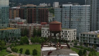 DX0001_013_017 - 5.7K aerial stock footage orbiting an old water tower atop a factory building, sunset, Downtown Portland, Oregon