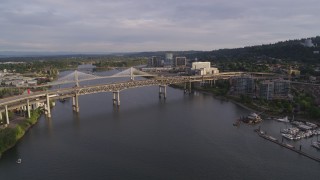 DX0001_014_007 - 5.7K aerial stock footage reverse over river from bridges, revealing marina, sunset, South Portland, Oregon