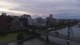 DX0001_014_025 - 5.7K aerial stock footage of Hawthorne Bridge and office buildings along the water, twilight, Downtown Portland, Oregon