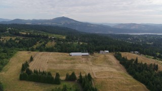 DX0001_015_014 - 5.7K aerial stock footage approaching a farm and fields in Hood River, Oregon