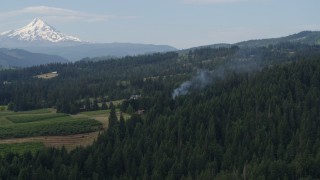 DX0001_015_024 - 5.7K aerial stock footage of smoke rising from trees near homes, reveal Mt Hood, Hood River, Oregon