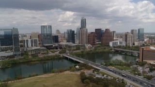 DX0002_102_008 - 5.7K aerial stock footage of First Street Bridge and Lady Bird Lake with view of the city skyline, Downtown Austin, Texas