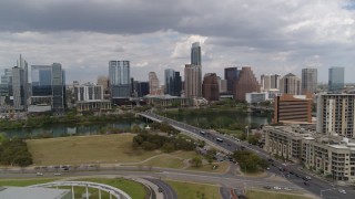 DX0002_102_009 - 5.7K aerial stock footage of a reverse view of First Street Bridge, Lady Bird Lake and the city skyline, Downtown Austin, Texas